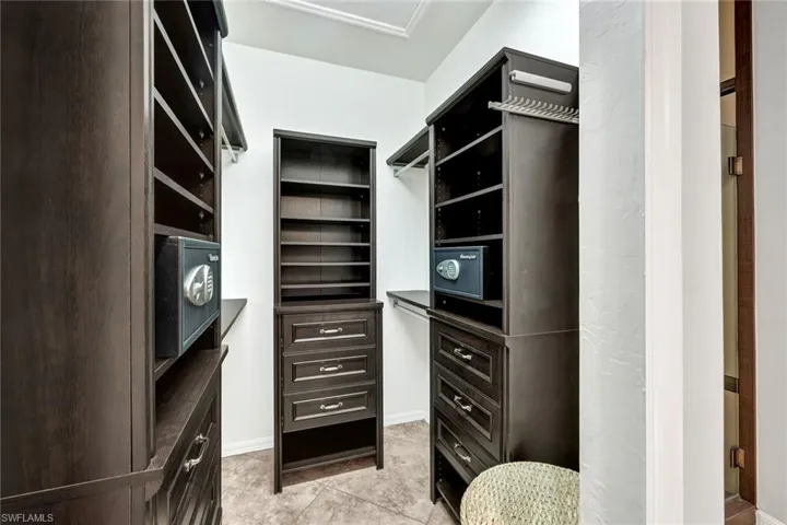 Custom cabinetry in primary bedroom closet with 2 safes