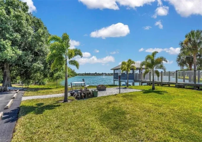 View of community featuring a water view and an outdoor fire pit
