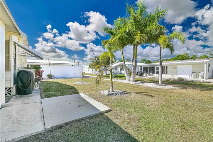 View of grassy yard featuring a patio
