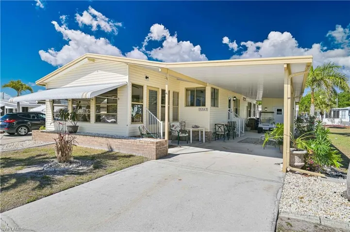 Manufactured / mobile home with a carport, concrete driveway, a porch, and entry steps