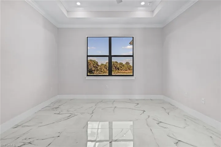 Spare room with a raised ceiling and crown molding