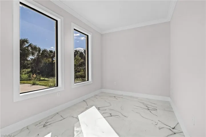 Unfurnished room featuring crown molding
