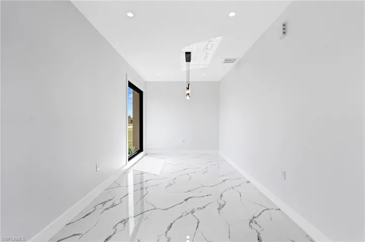 Unfurnished room featuring light marble finish floors and recessed lighting