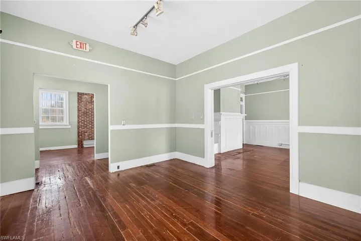 Spare room with dark wood-style floors and track lighting