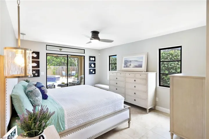Tiled bedroom featuring ceiling fan and access to outside