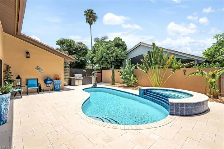 View of swimming pool featuring an in ground hot tub, area for grilling, and a patio