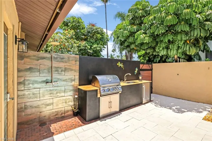 View of patio featuring area for grilling, a grill, and sink