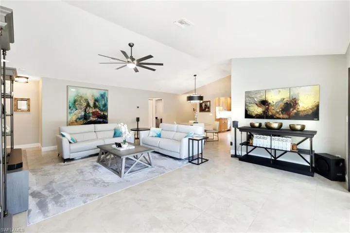Living room featuring vaulted ceiling and ceiling fan