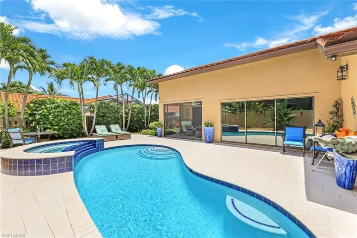 View of swimming pool featuring a sunroom, a patio, and an in ground hot tub