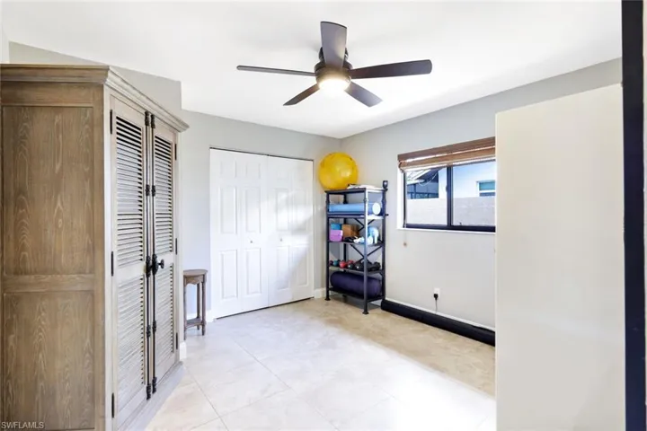 Unfurnished bedroom with ceiling fan and light tile patterned floors