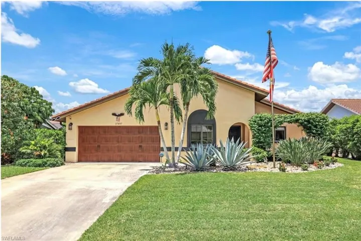 Mediterranean / spanish-style house with a garage and a front lawn