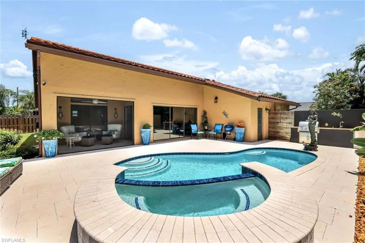View of pool featuring a patio, an outdoor kitchen, and an in ground hot tub