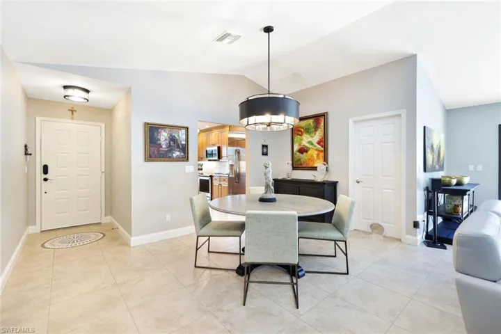 Dining area with lofted ceiling and light tile patterned floors