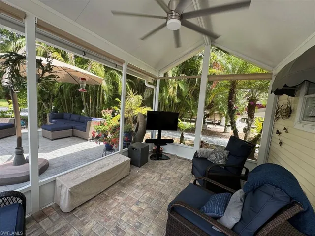 Sunroom / solarium with ceiling fan, a healthy amount of sunlight, and lofted ceiling