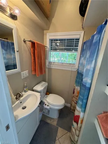 Bathroom with tile patterned flooring, vanity, and toilet