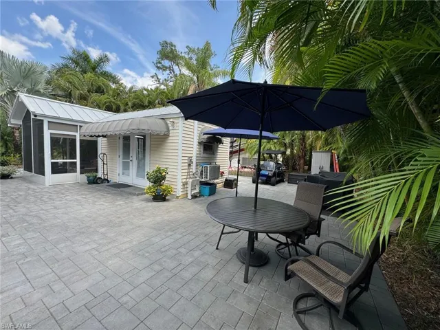 View of patio featuring a sunroom, central air condition unit, and french doors