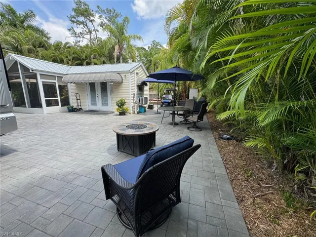 View of patio / terrace featuring a sunroom and an outdoor fire pit