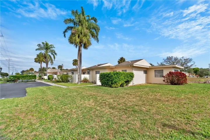 Ranch-style house with a front lawn and stucco siding