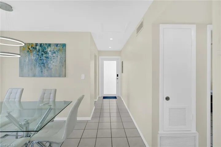 Corridor with light tile patterned floors and recessed lighting