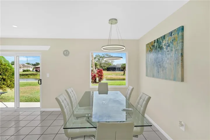 Dining area with light tile patterned floors, plenty of natural light, and a water view