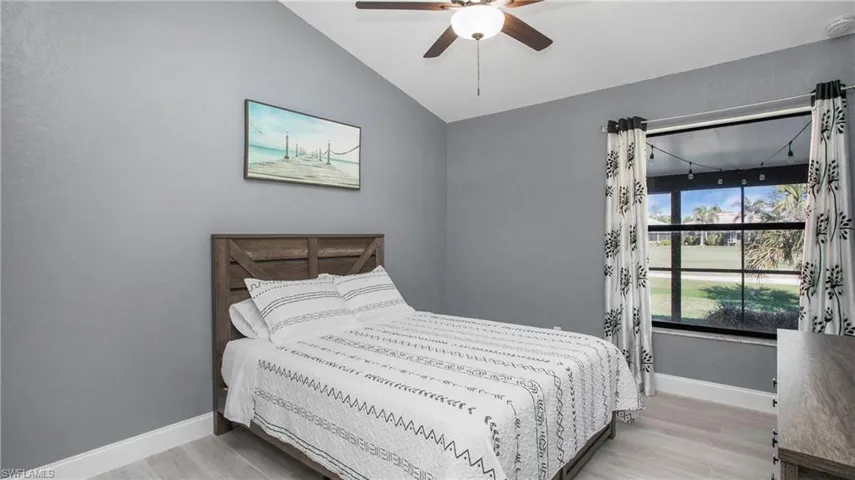 Bedroom featuring ceiling fan, light hardwood / wood-style flooring, and lofted ceiling
