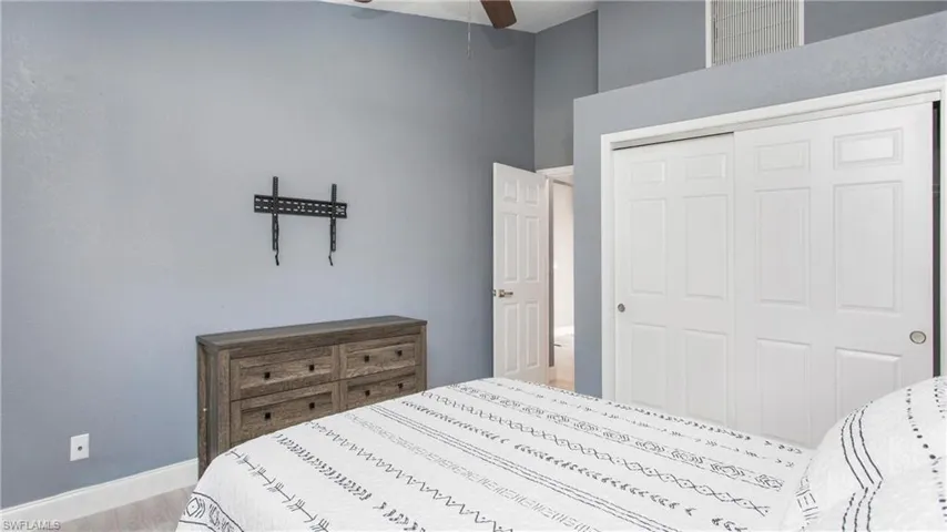Bedroom with ceiling fan, light hardwood / wood-style flooring, and a closet