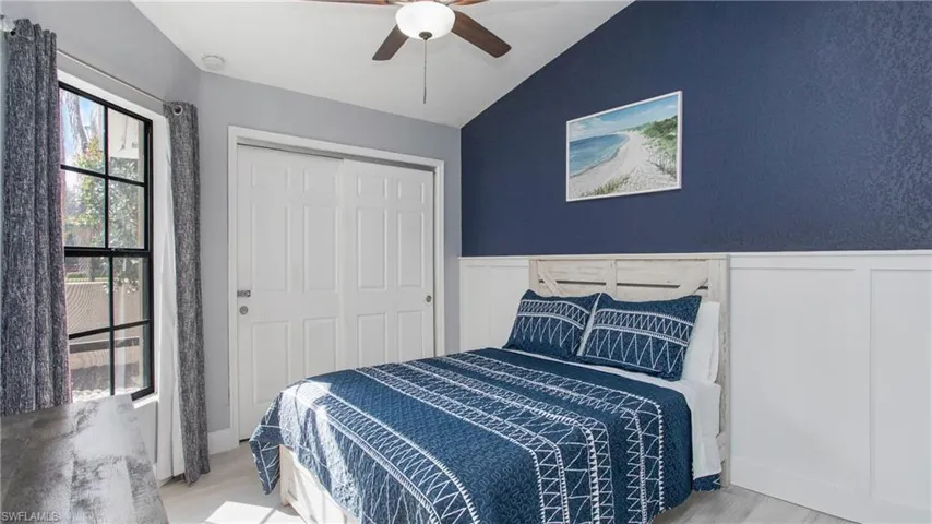 Bedroom with ceiling fan, vaulted ceiling, light hardwood / wood-style floors, and a closet