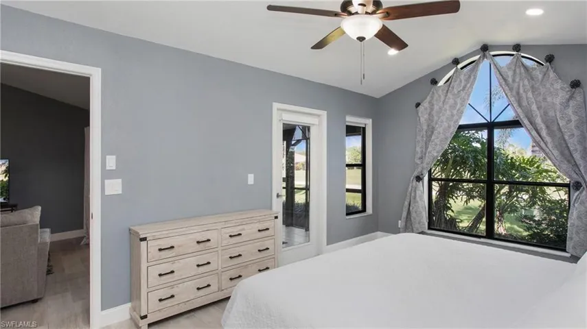 Bedroom featuring ceiling fan, light hardwood / wood-style flooring, and lofted ceiling