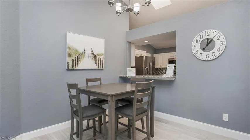 Dining area with a chandelier, a high ceiling, and light wood-type flooring