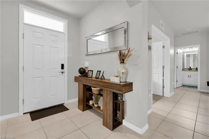 Entryway with baseboards and light tile patterned floors