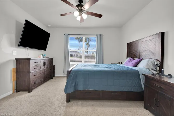 Bedroom featuring light carpet and a ceiling fan