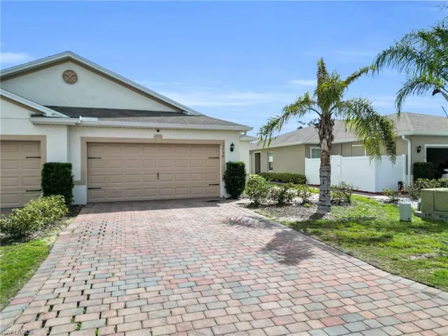 Ranch-style house featuring stucco siding, decorative driveway, and a garage