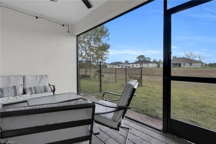 Sunroom / solarium featuring outdoor furniture, a residential view, and a ceiling fan