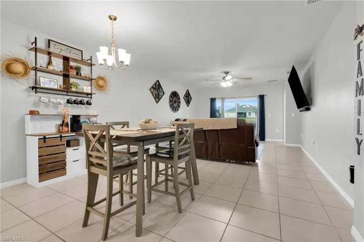 Dining area with hanging lights, light tile patterned flooring, and a ceiling fan