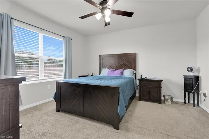 Bedroom with light colored carpet and ceiling fan