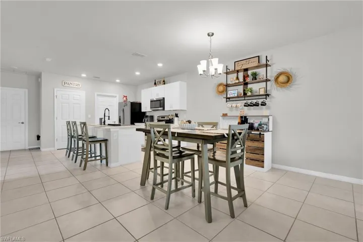 Dining room with light tile patterned floors and a chandelier