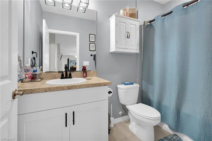 Bathroom with vanity, light tile patterned flooring, and shower / tub combo with curtain