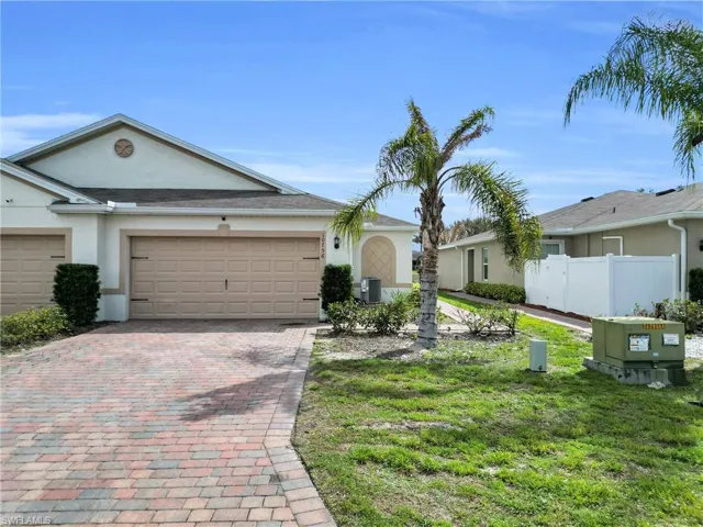 Ranch-style home featuring stucco siding, decorative driveway, and a garage