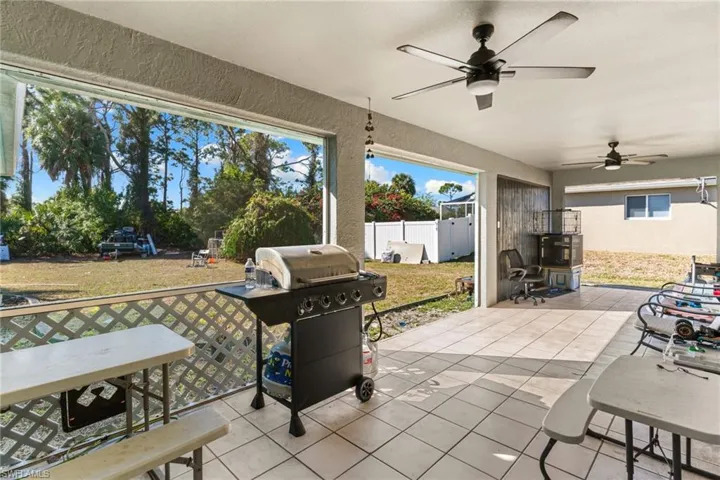 Fenced backyard with grilling area, a patio area, ceiling fan, and outdoor dining space