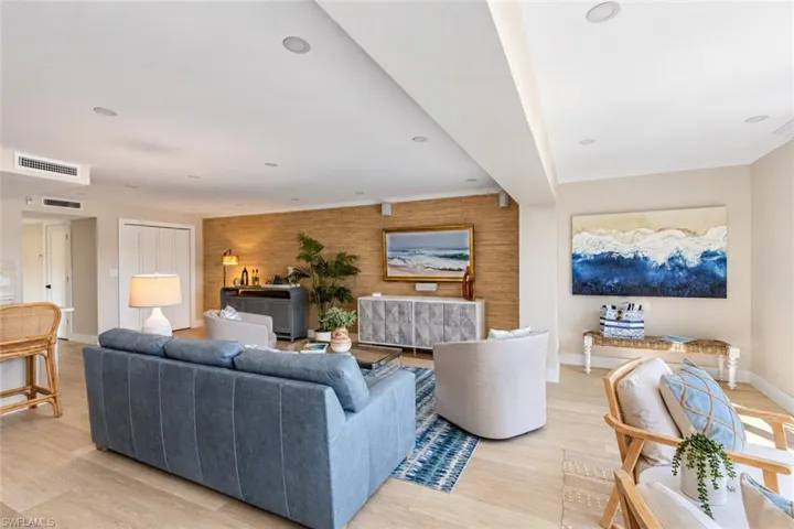 Open living area featuring wood-finish flooring, recessed lighting, and a textured wall covering