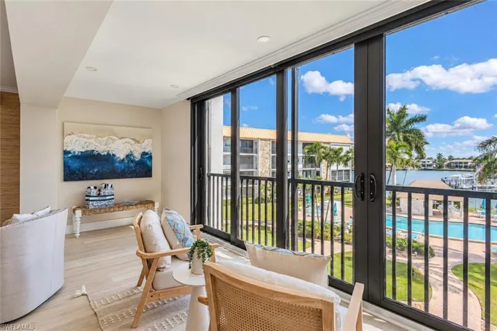 Floor-to-ceiling sliding glass panels, black metal framing, recessed lighting, and wood-finish flooring