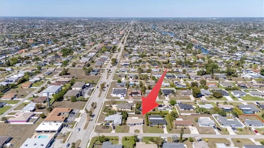 Aerial view of property and surrounding area featuring nearby suburban area