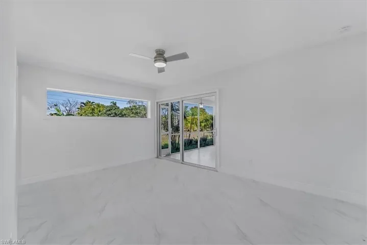Spare room with ceiling fan and light marble finish floors