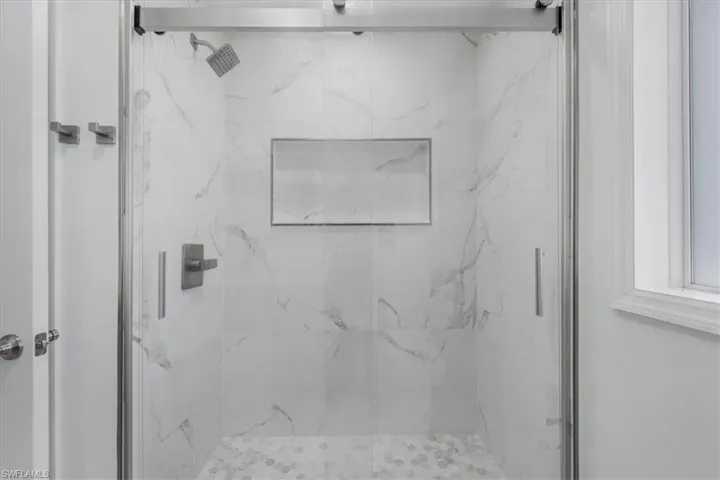 Full bathroom with a marble finish shower