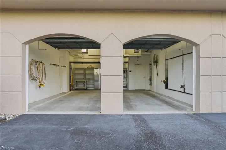 Garage featuring freestanding refrigerator and driveway - Virtually Edited Image
