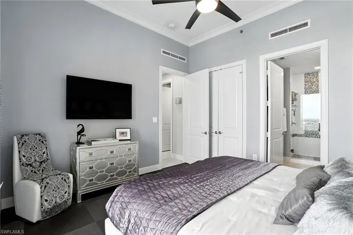 Bedroom with ornamental molding, ensuite bathroom, and a ceiling fan - Virtually Edited Image