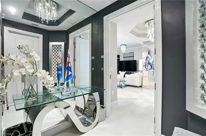 Hall with a chandelier, a tray ceiling, and ornamental molding - Virtually Edited Image