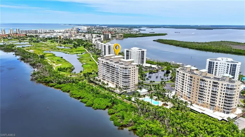 View of urban area with apartment complex / building and a large body of water - Virtually Edited Image