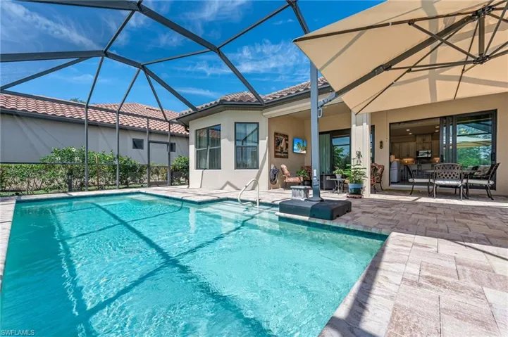 Outdoor pool with a patio area and glass enclosure