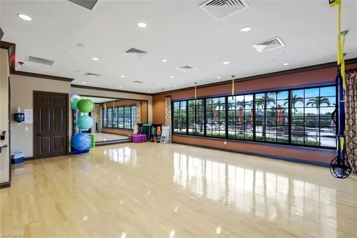Exercise area with recessed lighting, visible vents, and crown molding